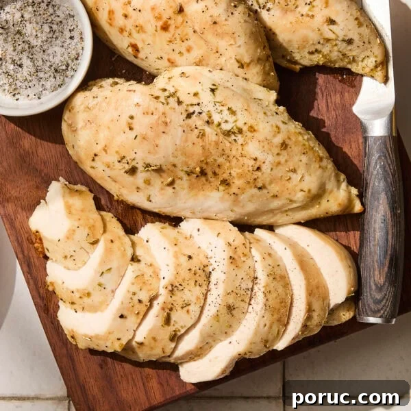 Sliced baked chicken breast on a cutting board.