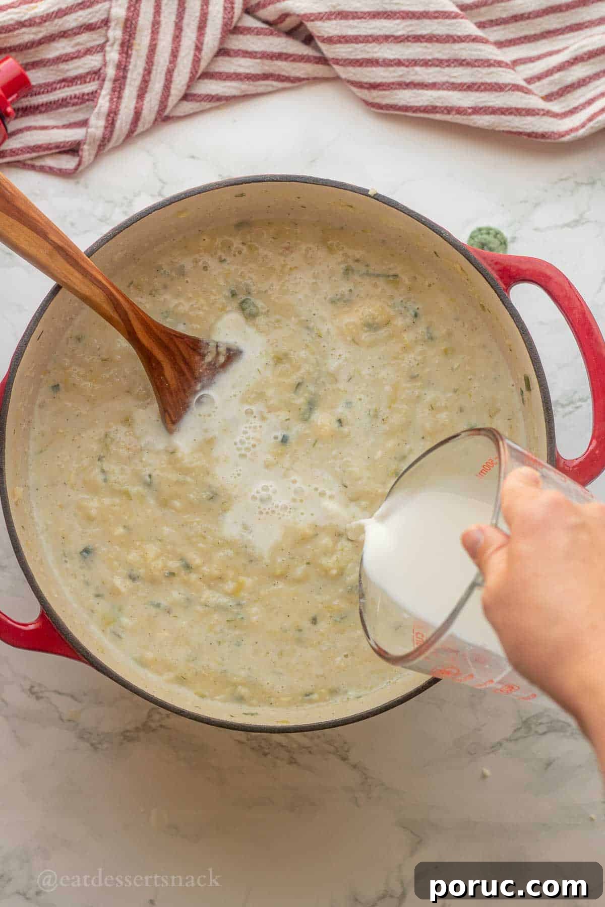 Creamy Potato, Leek & Cauliflower Soup Recipe 9 Pouring milk into potato soup pot.