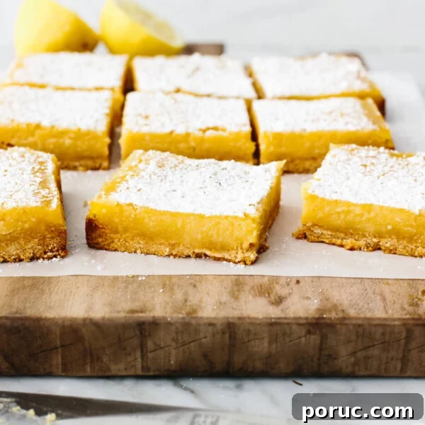 Sliced lemon bars on a wooden board.