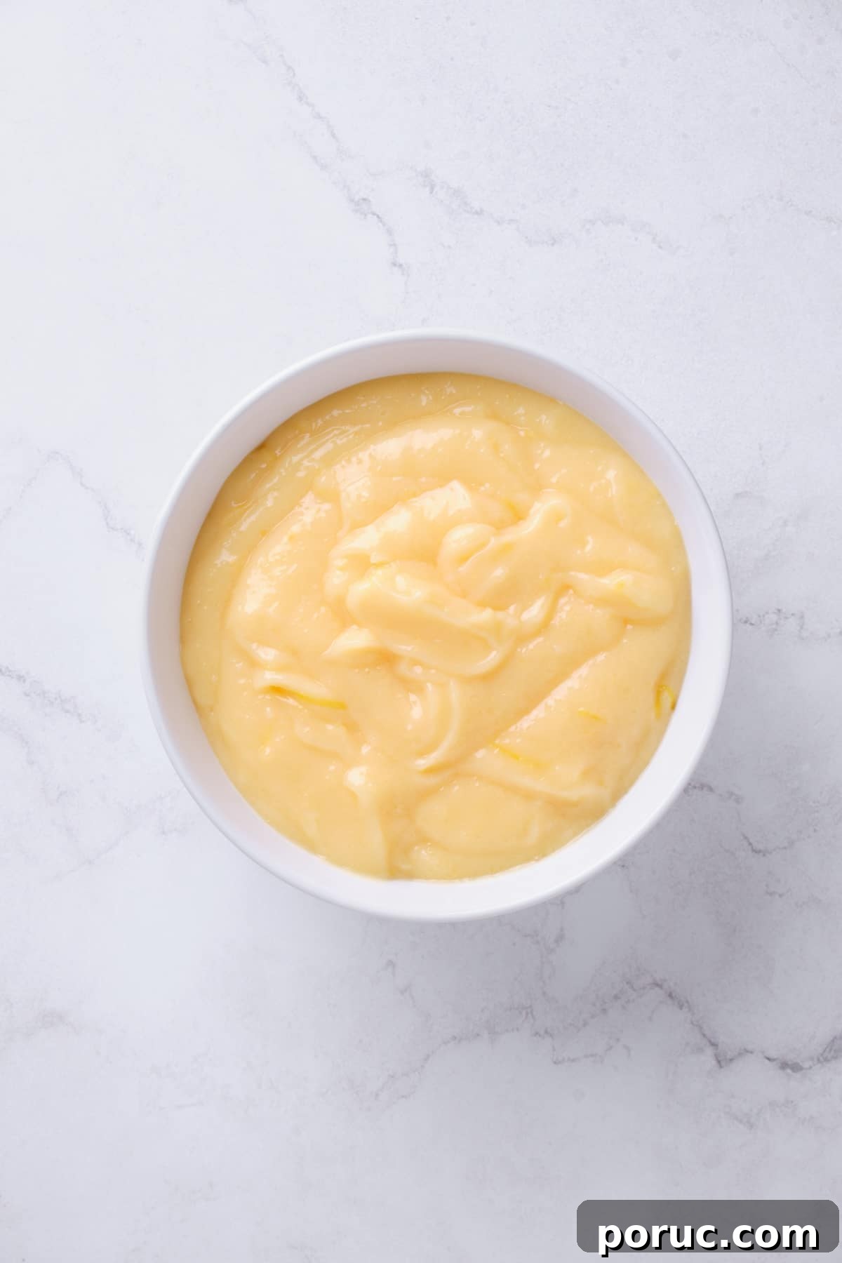 bowl of lemon curd cake filling.