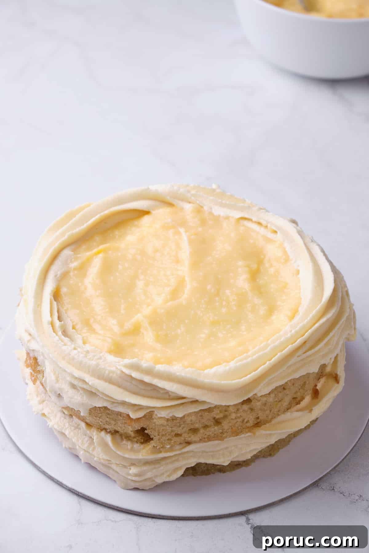 filling a cake with lemon curd filling.